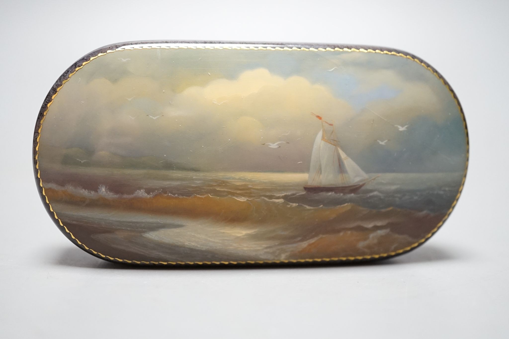 A Russian oval lacquered box, 10cm., and a porcelain box painted with ships approaching harbour